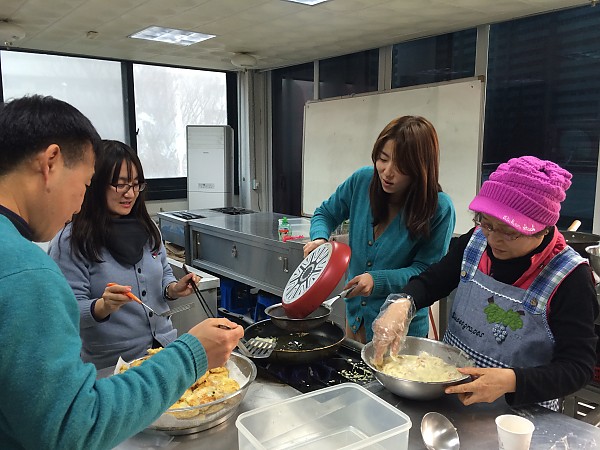 자원봉사자와 직원들이 모여서 음식조리