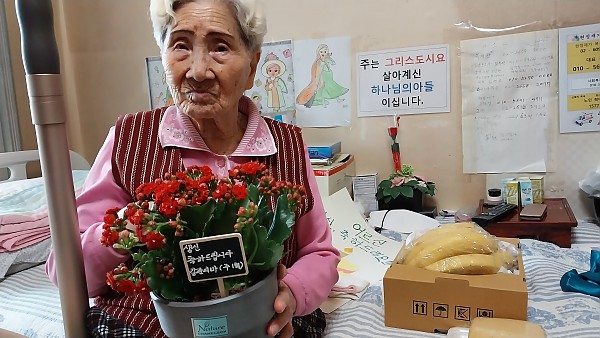 꽃 화분을 받으시는 어르신의 모습